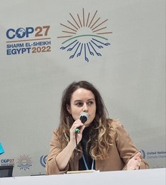 Julia Behrens auf der COP27 Julia Behrens spricht auf einem Podium bei den Klimaverhandlungen 2022 in Ägypten